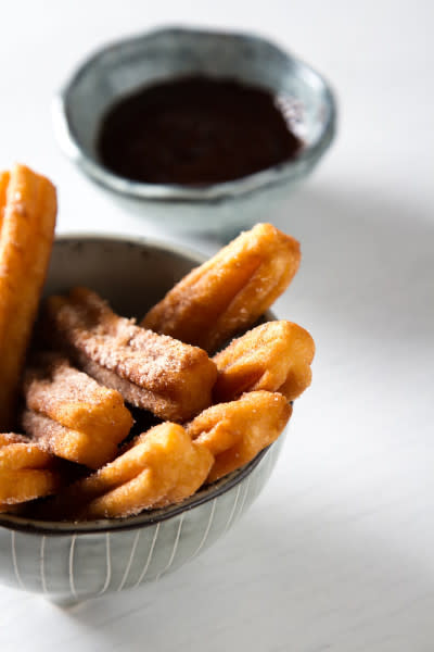 Churros in bowl with chocolate sauce