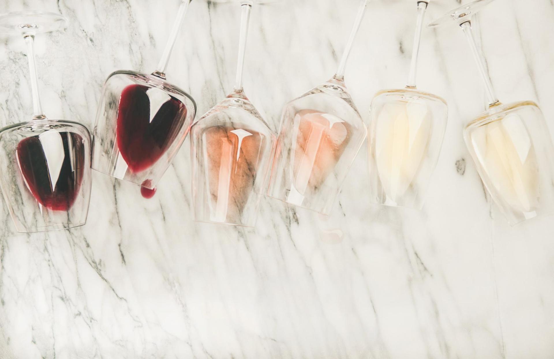 A line of wine glasses with varying colors of wine