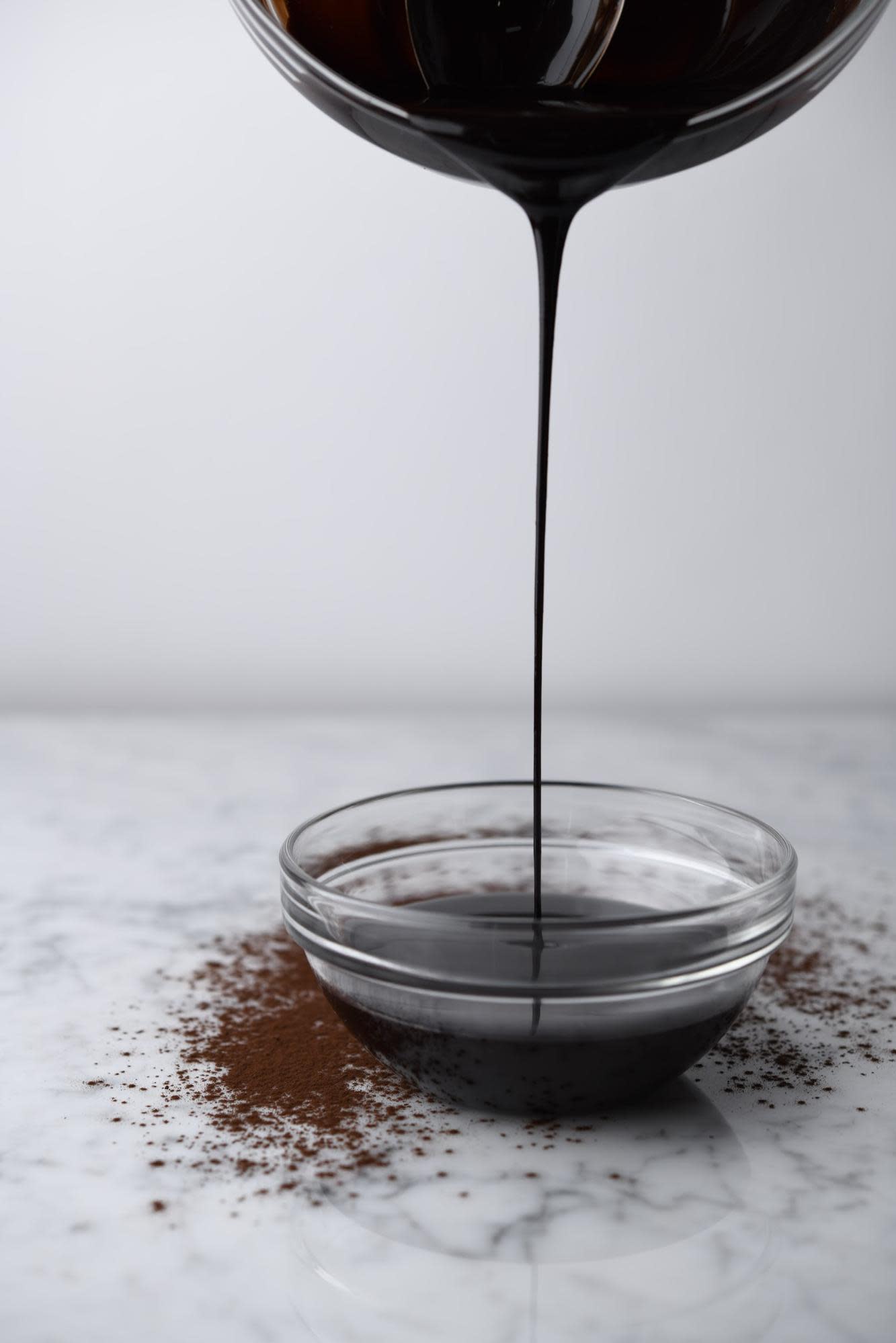 chocolate mirror glaze dripping into a bowl