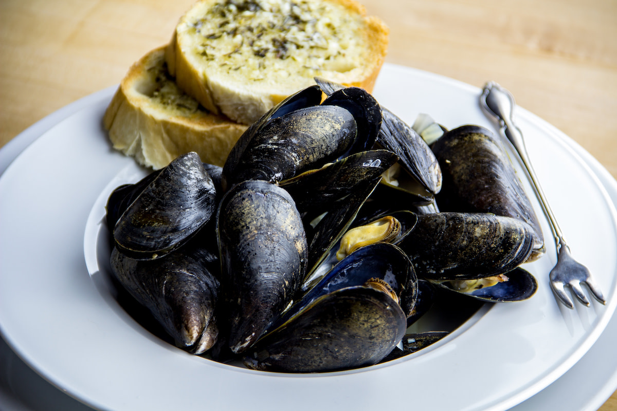 steamed mussels in a bowl with bread