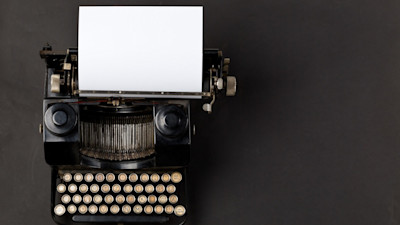 Vintage black typewriter with paper on black background