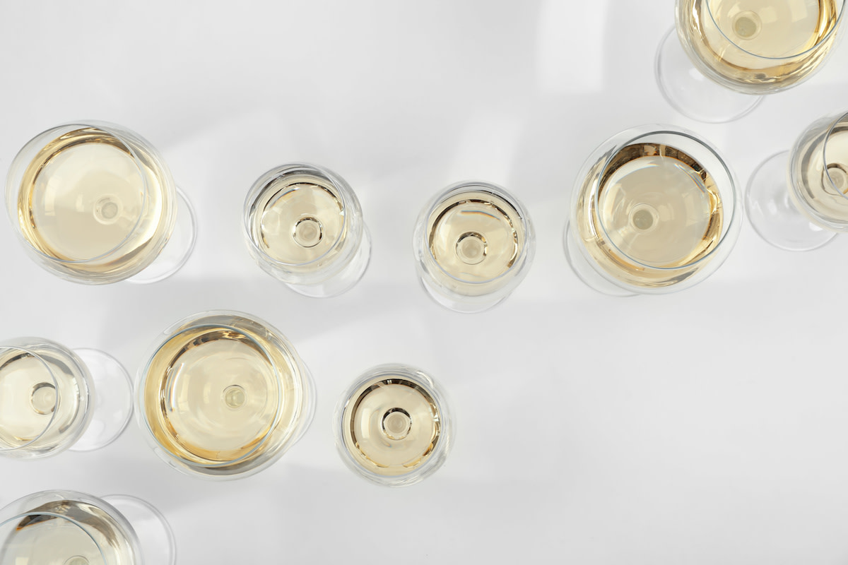 White wine in glasses on white background