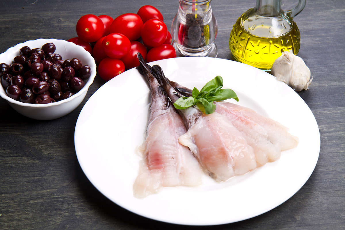 Raw monkfish filets with raw ingredients