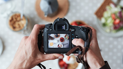 Person taking a picture of food with DSLR camera