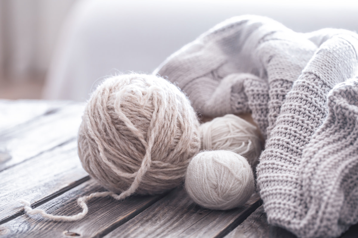 Sweater and balls of yarn on wood