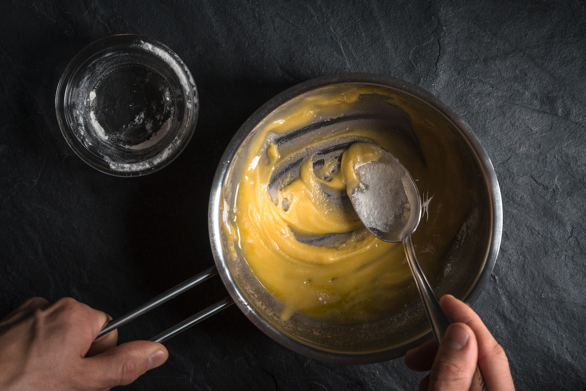 Person mixing together butter and flour in pot