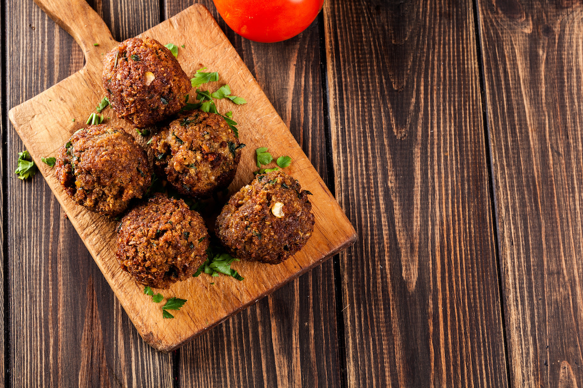 Falafel with garnish on wood cutting board