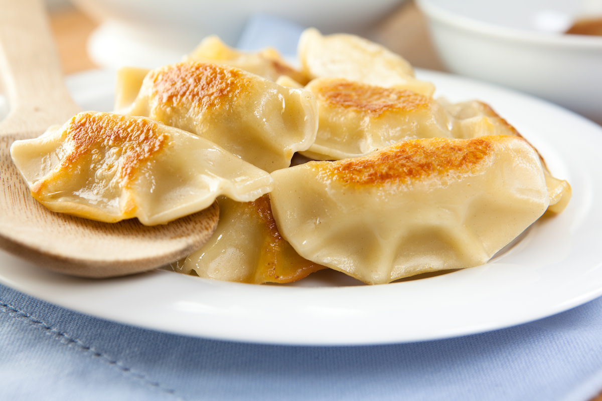 Polish pierogis on plate with wooden spoon