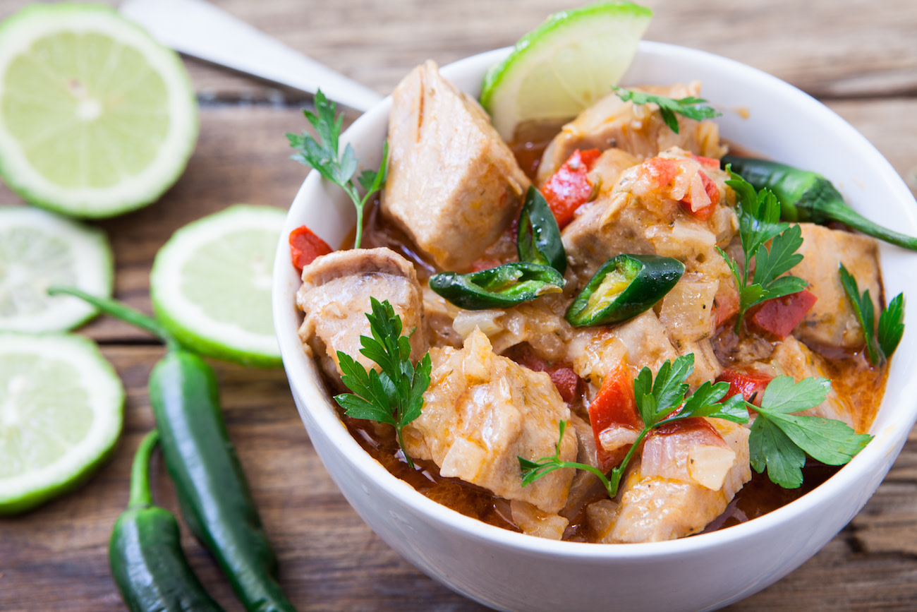 Fish tofu curry with garnish and limes