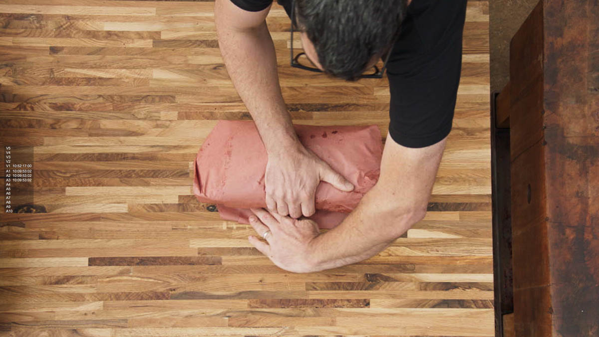 Aaron Franklin wrapping meat in red paper step 6