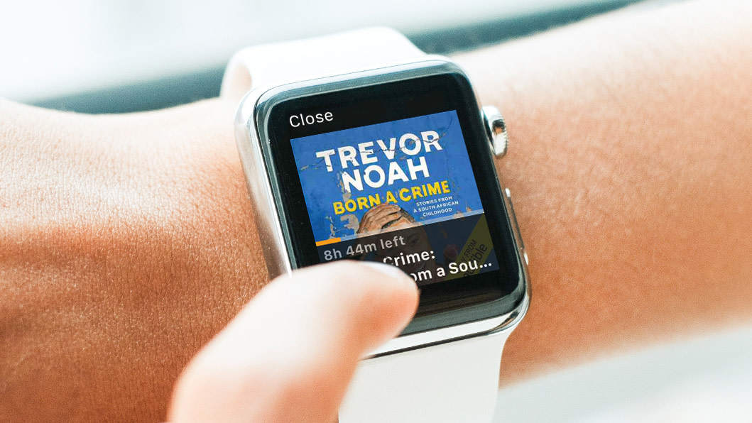 A close up of a person's wrist with Audible being used on Apple Watch. Trevor Noah's Audible book, Born a Crime, is displayed on it.