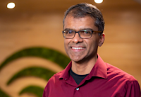 A headshot of Ian Moraes, who's smiling. He's wearing glasses and a red shirt. 
