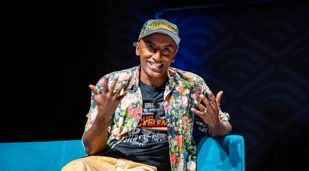 Chef Marcus Samuelsson on stage at Audible wearing an "Our Harlem" t-shirt.