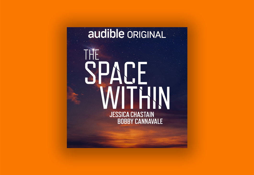 Set on a bright orange background is the cover art for "The Space Within." The Audible Original logo is at the top of the artwork, with the title text below in white large text, as well as Jessica Chastain and Bobby Cannavale who star in the story. The background of the artwork is an orange sunset.