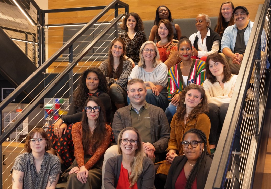 A group photo of Audible's Editors sitting on a stairwell, smiling. 