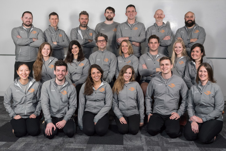Audible's marathon team posing in a group with matching grey sweatshirts.