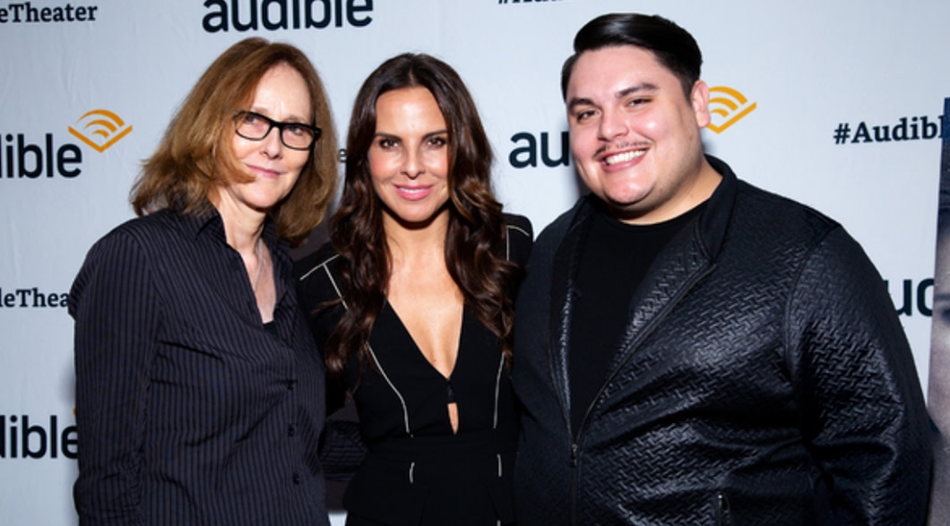 Directo Jo Bonney, actress Kate del Castillo and playwright Issac Gomez pose together in front of an Audible backdrop.