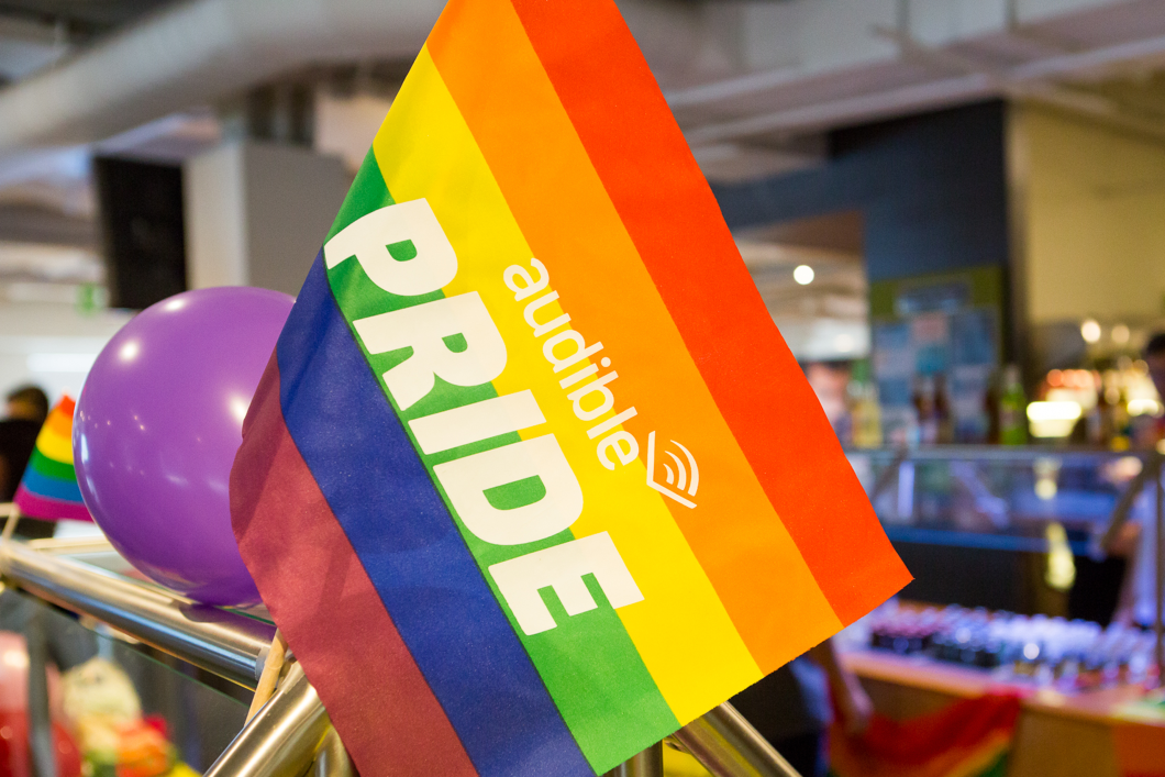 A rainbow flag with the words Audible Pride written across it sits front and center in the picture. It is decorating Audible's cafeteria at out headquarters in Newark.
