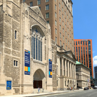 A close up of the front of the Audible Innovation Cathedral in downtown Newark with the street beyond it.