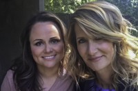 Producing partners Jayme Lemons and Laura Dern smile for the camera, their heads close together. The photo is cropped close so we see their heads and shoulders and some blurred trees in the background.