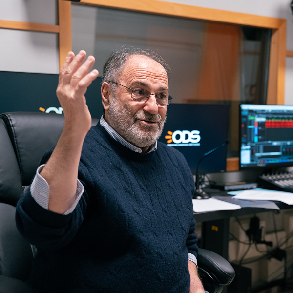 A man sits in a recording studio giving acting advice. 