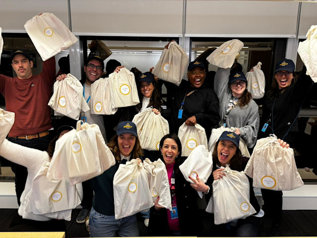 Employees in Brazil with some of the “comfort kits” they assembled for young cancer patients and their families.