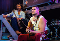 Nygel D. Robinson and Brian Quijada sit together onstage during a performance of “Mexodus.”