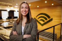 A headshot of Bennett Chiles. She's wearing a blazer and has shoulder-length hair. The Audible logo is visible on a wall behind her. 