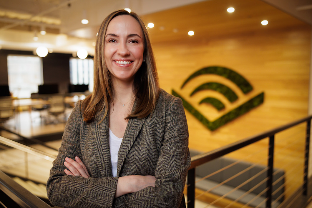 A headshot of Bennett Chiles. She's wearing a blazer and has shoulder-length hair. The Audible logo is visible on a wall behind her. 