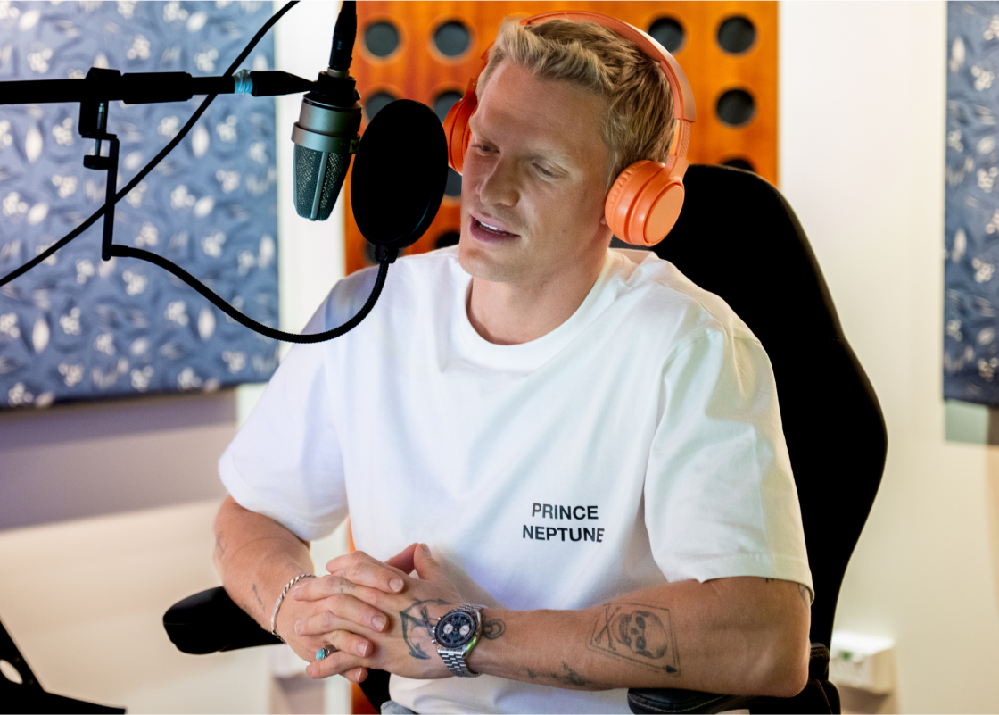 Cody Simpson sits in a recording studio at a microphone performing.