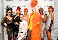 Sasha Velour's drag revue, NightGowns, stands against a photo backdrop featuring the Tribeca Festival, Audible and AT&T logos.  Sasha Velour is squatting down in front of the six drag queens that make up the review.  