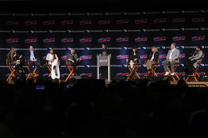 a group of celebrities sitting on a stage during panel conversation
