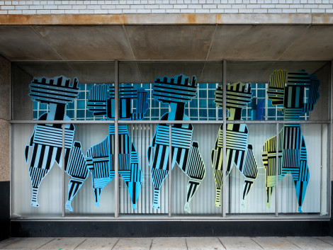 a storefront with persony colorful striped figures
