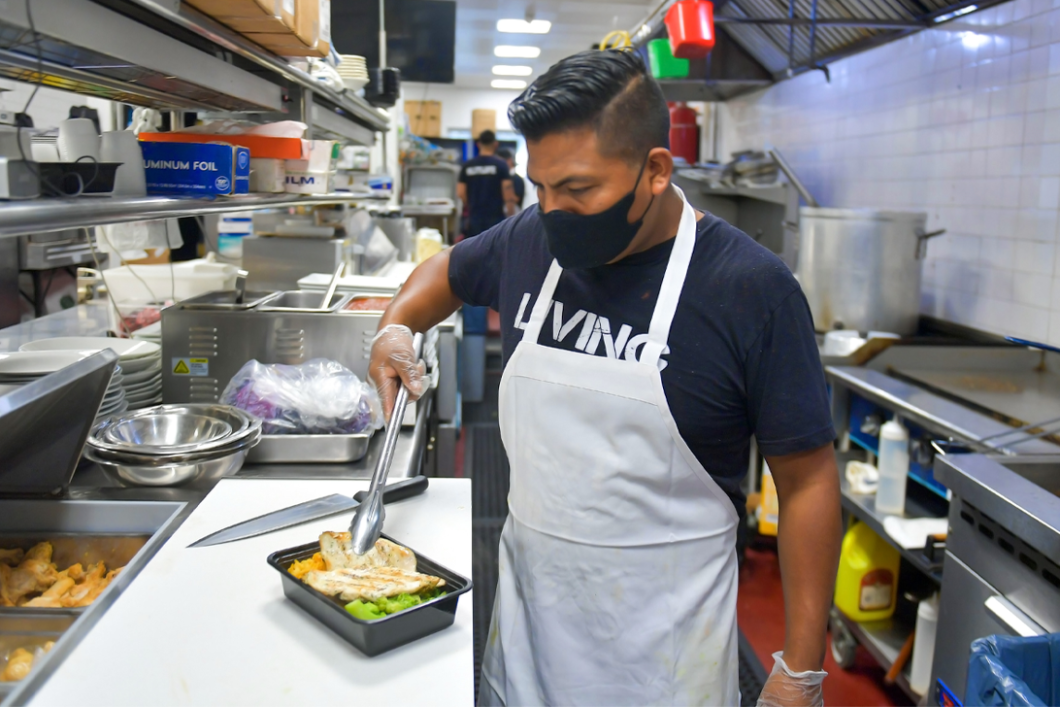 A cook from a NWK participating restaurant prepares a grilled chicken meal.