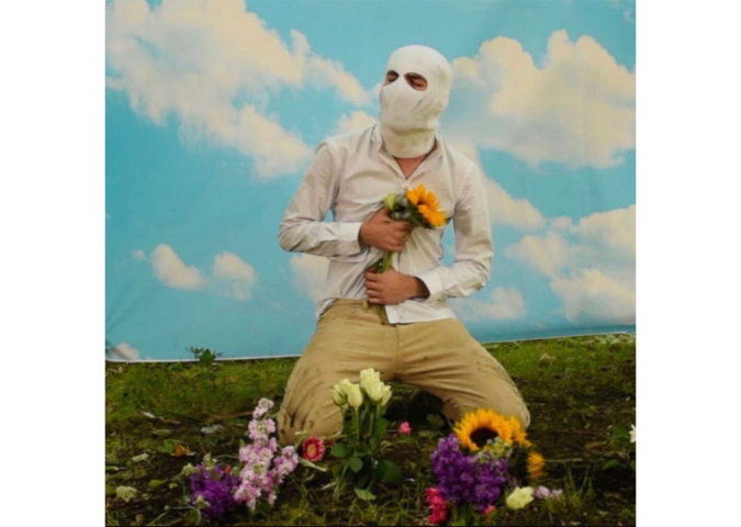 a person kneeling in a field with flowers 