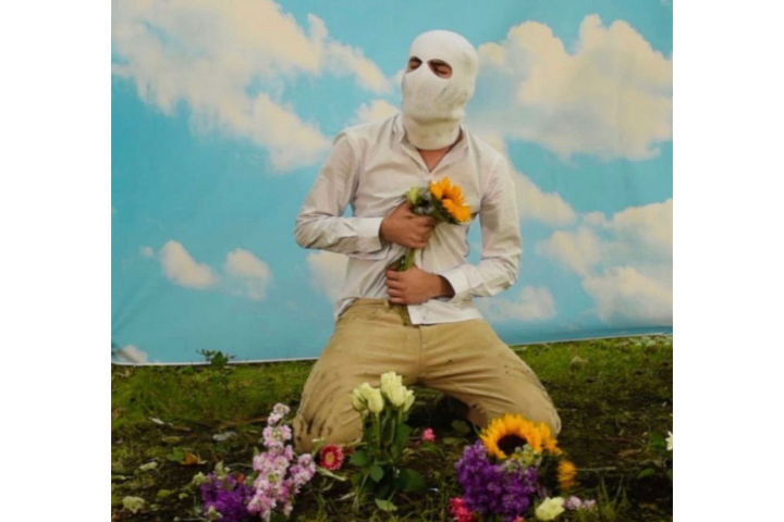 a person kneeling in a field with flowers 