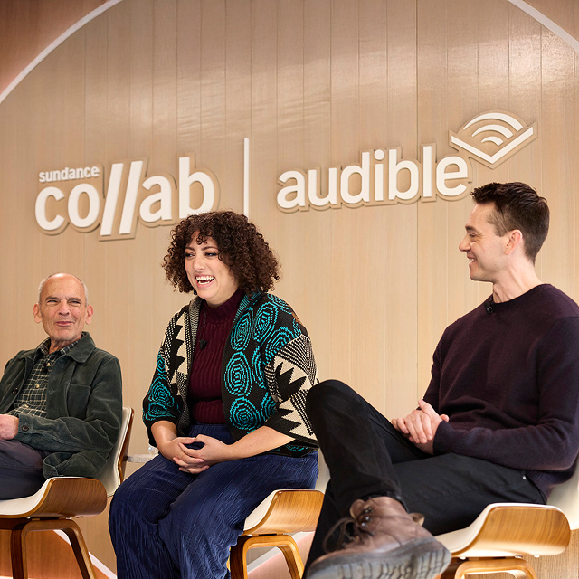 Three people sit in chairs on a stage for a panel. On the wall behind them are the Sundance Collab and Audible logos.
