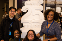 A photo shows four Audible employees standing around a white sculpture that says "Audible 25 Years".