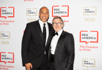 Audible founder and Executive Chairman Don Katz stands on the red carpet at the PEN America gala with Senator Cory Booker. Katz is wearing a tuxedo. Booker is wearing a black suit and tie. Behind them, the backdrop is white with the PEN America logo repeating across it with the tagline, "The Freedom to Write."