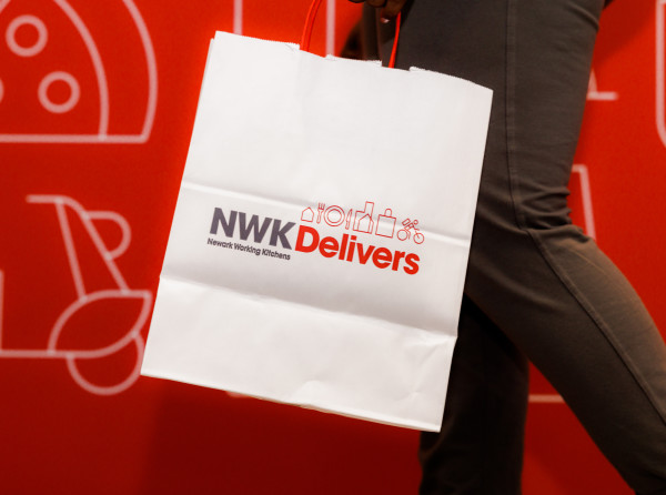 White NWK Delivers bag with logo and food-related icons.