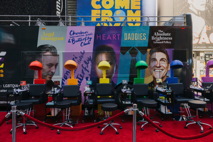 A look at the unique immersive listening experience in which visitors were treated to a full Pride-ready look by Broadway makeup and hair artists, while listening to stories from Audible’s LGBTQIA+ collection. Stationary hair dryer stations in red, orange, yellow, green, blue and purple are lined up in front of Audible's double decker bus.