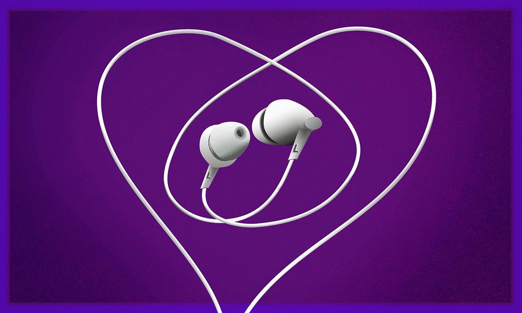 White earphones against a purple background. The earphones cord is looped in a heart shape.
