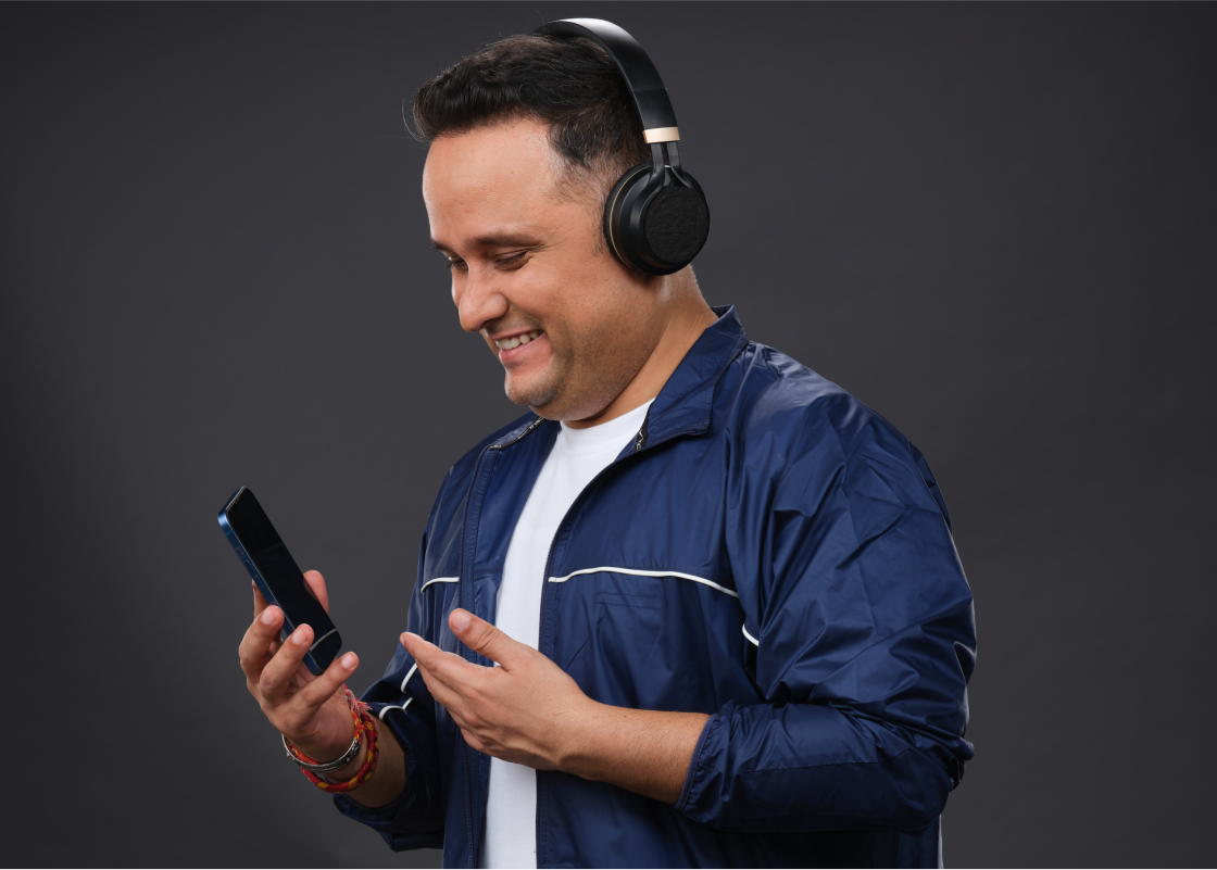 Amish Tripathi stares down at his phone, headphones on as he listens to his audiobook.