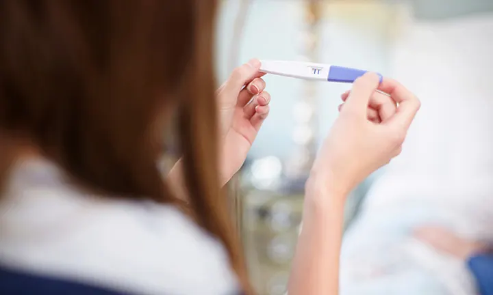 Woman looking at a pregnancy test.