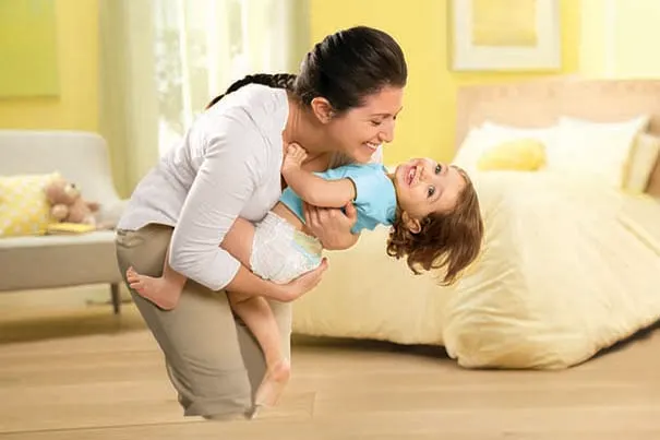 Smiling mother and toddler playing. 