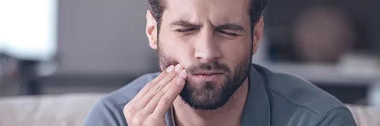 Man suffering from pain caused by receding gums 