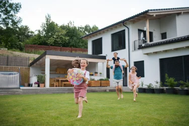 Immobilie kaufen: Hier sehen Sie eine Familie in einem Einfamilienhaus.