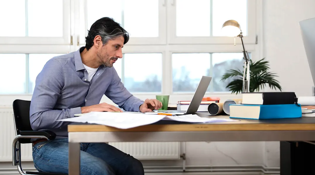 Hier sollten Sie einen Mann sehen, der am Laptop arbeitet.