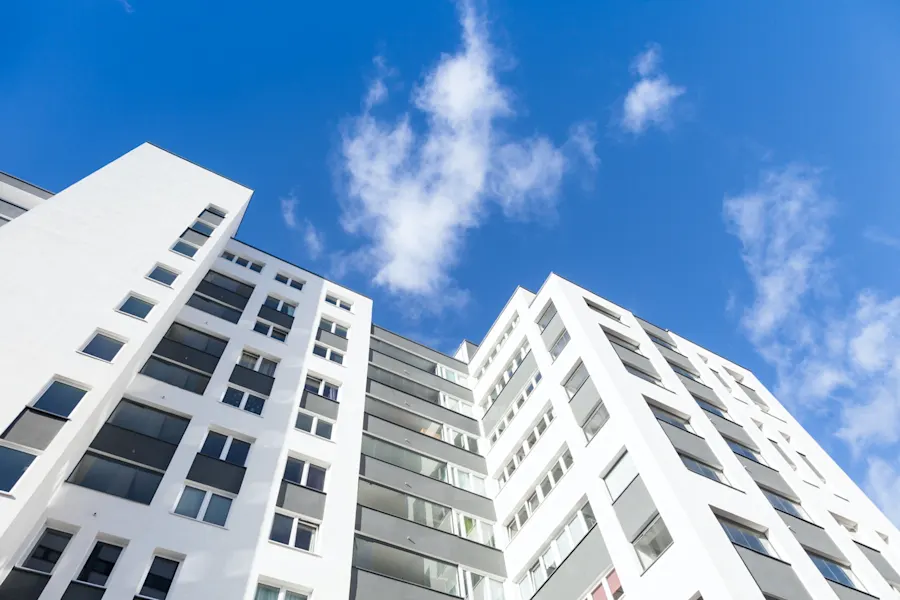 Hier sehen Sie ein modernes Haus in Hamburg. Der Himmel ist Blau mit einigen Wolken. Die Perspektive ist von unten nach oben.