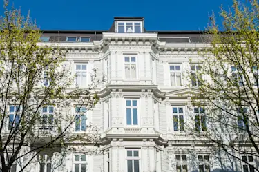 Hier sehen Sie ein Bild für den Immobilienkauf-Artikel, wo ein weißer Altbau zu sehen ist.